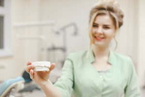 woman doctor orthodontist shows a plaster cast of P5AF6LN