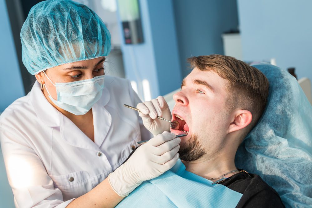 dentist-doing-a-dental-treatment-on-a-patient-P7H2UAX