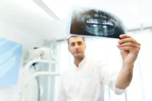 young-doctor-dentist-man-in-white-uniform-standing-ZWF4TD2 (1)