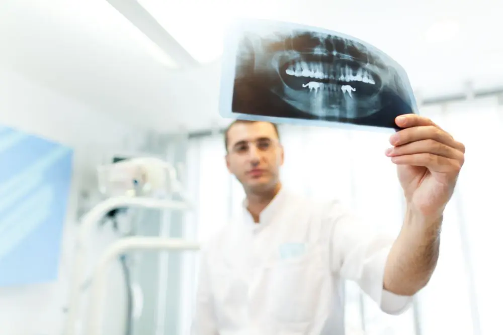young-doctor-dentist-man-in-white-uniform-standing-ZWF4TD2 (1)