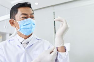 dentist putting on latex gloves 4FD5VGS